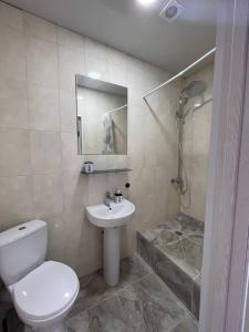 a bathroom with a toilet and a sink and a shower at Отель Меридиан in Zolotonosha