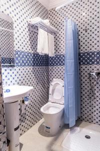 a blue and white bathroom with a toilet and a sink at HOTEL LA VALLEE DES KASBAHS CHEZ ILYAS in Tinerhir