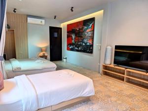 a hotel room with two beds and a flat screen tv at Seava House Ao-Nang Krabi in Ao Nang Beach