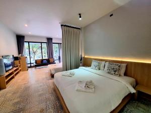 a bedroom with a large bed and a living room at Seava House Ao-Nang Krabi in Ao Nang Beach