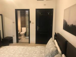 a bedroom with a black door and a bathroom at Modern two bedroom appartment in Amman