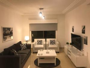 a living room with a couch and a table at Modern two bedroom appartment in Amman