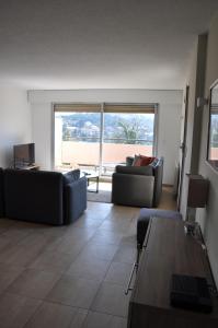 uma sala de estar com dois sofás e uma mesa em Magnifique appartement vue mer la turbie em La Turbie