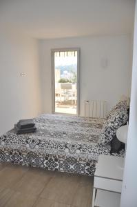 um quarto com uma cama e uma porta para um pátio em Magnifique appartement vue mer la turbie em La Turbie