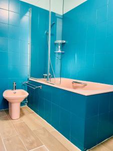een blauwe badkamer met een wastafel en een toilet bij Luckyhouse Chatou-ville des impressionnistes - 10km Paris La Défense 20km Stade de France in Chatou
