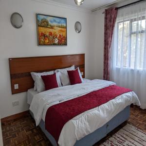 1 dormitorio con 1 cama grande con almohadas rojas en Westlands bliss haven paradise fully furnished 1bedroom apartments, 