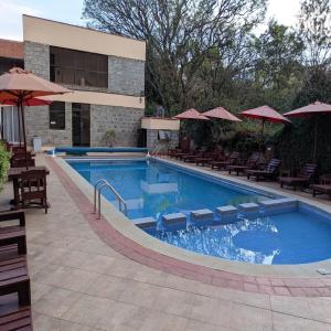 a swimming pool with chairs and umbrellas next to a building at Westlands bliss haven paradise fully furnished 1bedroom apartments 