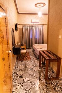 a room with a bed and a table on a tile floor at HOTEL LA VALLEE DES KASBAHS CHEZ ILYAS in Tinerhir