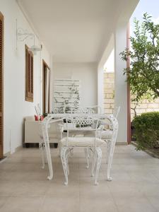 a white dining table and chairs on a patio at B&B Virò in Campi Salentina