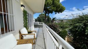 un balcone di una casa con due sedie e alberi di Riells de Mar A1 a L'Escala