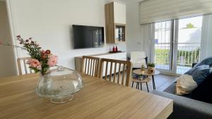 un soggiorno con tavolo e vaso di fiori di Riells de Mar A1 a L'Escala