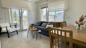 un soggiorno con un divano blu e un tavolo di Riells de Mar A1 a L'Escala