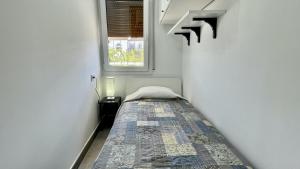 una piccola stanza con un letto e una finestra di Riells de Mar A1 a L'Escala