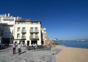 two people standing in front of a building on the beach at Ribalta 1-1 in L'Escala
