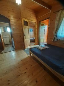 um quarto com uma cama num chalé de madeira em Zielony Zakątek domki i pokoje 661-038-537 em Polańczyk