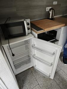 a small kitchen with a microwave and a refrigerator at Smart Appart in Cologne