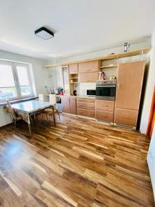 uma cozinha com piso em madeira e uma mesa em Komfortowy pokój dla dwojga z balkonem Marcinkowicka em Nowy Sącz