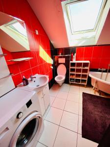 czerwona łazienka z pralką i umywalką w obiekcie Komfortowy pokój dla dwojga z balkonem Marcinkowicka w Nowym Sączu