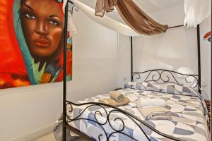 1 dormitorio con 1 cama con una pintura en la pared en 1 bedroom Giuly sea views in Los Cristianos en Los Cristianos