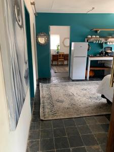 uma cozinha com paredes azuis e um frigorífico em The Vine Cottage at Viva Connect em Cullinan