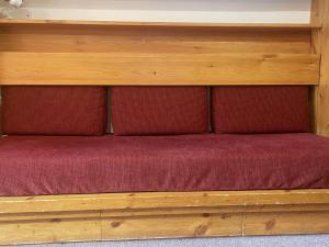 a bed with two red cushions on a wooden shelf at Appartement Méribel, 2 pièces, 6 personnes - FR-1-411-717 in Les Allues