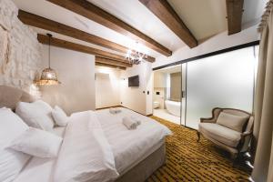 - une chambre avec un grand lit blanc et une chaise dans l'établissement Dwór Bogucin Hotel&Restauracja, à Bogucin