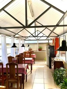 a dining area with tables and chairs and a kitchen at Carlos Paz Departamentos in Villa Carlos Paz