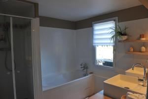 une salle de bain avec une baignoire, une douche et un lavabo dans l'établissement L'Appart Gîte de Charme, à Compiègne 10 autres photos