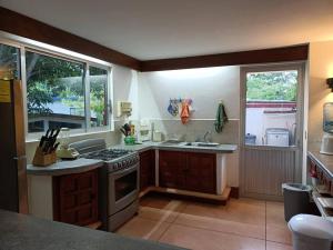 a kitchen with a stove and a sink and two windows at La siempre bella Tamiahua in Tamiahua