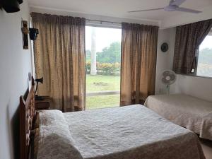 a bedroom with two beds and a large window at La siempre bella Tamiahua in Tamiahua