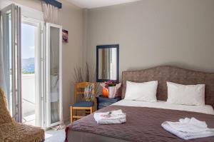 ein Schlafzimmer mit einem Bett mit zwei Handtüchern darauf in der Unterkunft Christina Rooms in Adamas