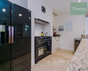 a kitchen with a black stove and a counter at Huge Four Bedroom Townhouse By PureStay Short Lets & Serviced Accommodation Bath in Bath
