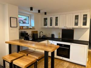 eine Küche mit weißen Schränken und einer Arbeitsplatte aus Holz in der Unterkunft Apartament Ratvika in Ålesund + 15 Fotos