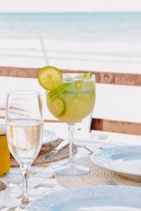 a drink in a glass with a lime on a table at Pousada Estrela da Luz Beach in Ceará-Mirim