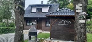 una pequeña casa con una estatua delante de ella en Chatička pod Lysou, en Ostravice