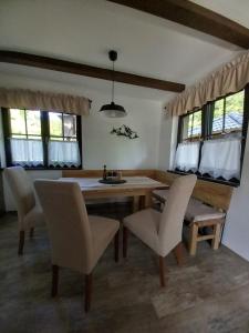 a dining room with a table and chairs and windows at Chatička pod Lysou in Ostravice