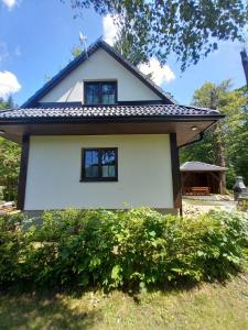 a small white house with two windows on it at Chatička pod Lysou in Ostravice