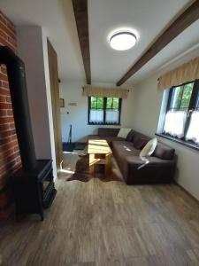 a living room with a leather couch and a table at Chatička pod Lysou in Ostravice