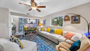 sala de estar con sofá y ventilador de techo en Zen Jungle House by Busch Gardens Sleeps 10 with Outdoor Games and bikes!, en Tampa
