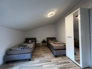 a bedroom with two beds and a mirror at Ferienwohnung Bad Säckingen in Bad Säckingen