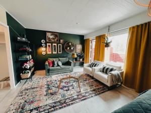 sala de estar con sofá y alfombra en Pieni lomahuoneisto ja ulkoporeallas, en Mynämäki