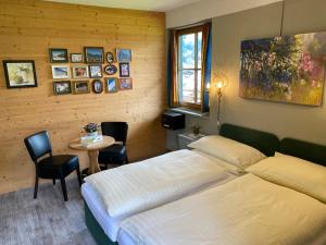 a bedroom with two beds and a table with chairs at Hotel Edelweiss Kitzbühel in Kitzbühel