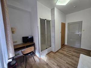 a bathroom with a desk and a shower in a room at Hotel Haus Isenburg in Neu Isenburg