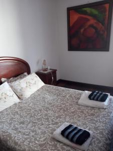 een slaapkamer met een bed met twee handdoeken erop bij MG - Aluguer de quartos in Felgueiras