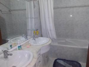 een badkamer met 2 wastafels en een bad bij MG - Aluguer de quartos in Felgueiras