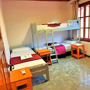 a room with two bunk beds and two tables at Apartment El sueño de Julieta in Puerto Iguazú