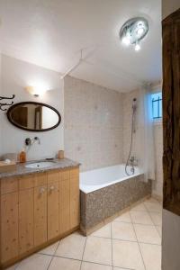 een badkamer met een bad, een wastafel en een spiegel bij Chalet des Écureuils - Grand chalet familial proche des pistes avec parking in Courchevel
