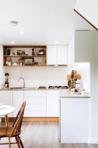 a kitchen with white cabinets and a table at The Stable Lofts in Carrick