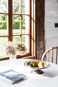 a table with a plate of fruit and a vase of flowers at The Stable Lofts in Carrick +36 photos
