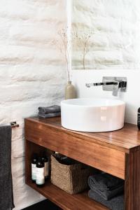 a bathroom with a white sink on a wooden counter at The Stable Lofts in Carrick